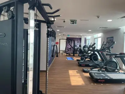 a gym with a row of treadmills and machines at Studio near Marina - 15mins drive in Dubai