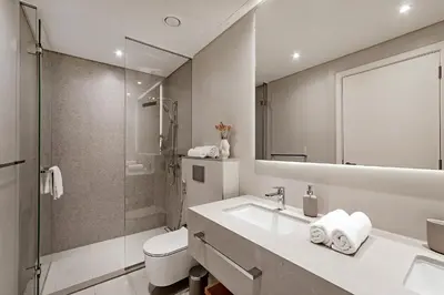 a bathroom with a sink and a toilet and a shower at La Vie Apartments in Dubai