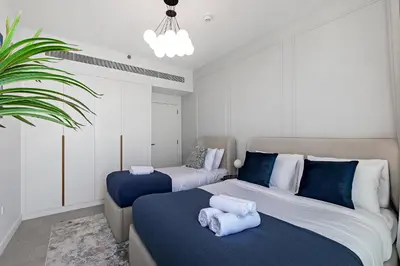 a bedroom with two beds with blue and white at La Vie Apartments in Dubai