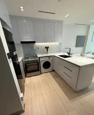 a kitchen with white cabinets and a sink and a dishwasher at Luxury 1BR Apartment In Binghatti Corner, High Floor In JVC in Dubai