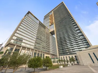 two tall buildings with trees in front of them at YOUR STAY CORPORATE RESIDENCES DIFC Burj Daman in Dubai