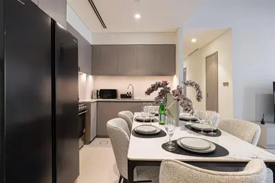 a dining room with a table and chairs and a kitchen at Luxury 2BR Downtown Dubai, Grande Signature with Stunning Burj Khalifa and Dubai Opera Views, steps to Dubai Mall by La Brisa in Dubai