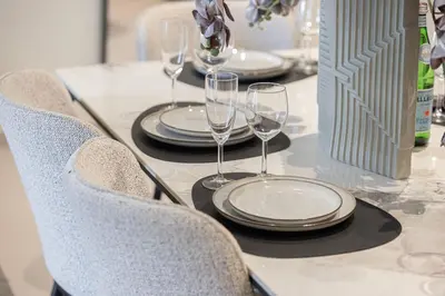 a table with plates and wine glasses on it at Luxury 2BR Downtown Dubai, Grande Signature with Stunning Burj Khalifa and Dubai Opera Views, steps to Dubai Mall by La Brisa in Dubai