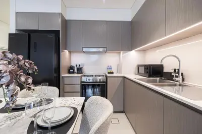 a kitchen with a table and chairs and a sink at Luxury 2BR Downtown Dubai, Grande Signature with Stunning Burj Khalifa and Dubai Opera Views, steps to Dubai Mall by La Brisa in Dubai