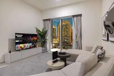 a living room with a couch and a flat screen tv at Luxury 2BR Downtown Dubai, Grande Signature with Stunning Burj Khalifa and Dubai Opera Views, steps to Dubai Mall by La Brisa in Dubai