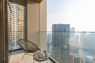 a balcony with two chairs and a view of a city at PENINSULA ONE 1BR by Design Studio in Dubai