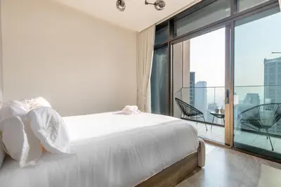 a bedroom with a white bed and a balcony at PENINSULA ONE 1BR by Design Studio in Dubai