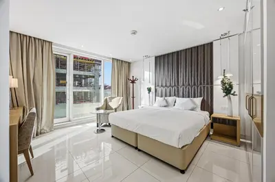 a hotel room with a bed and a desk and window at 3 Bedroom unit at DAMAC maison Canal Views in Dubai