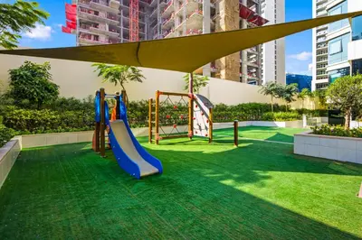 a playground with a slide and a swing at 3 Bedroom unit at DAMAC maison Canal Views in Dubai