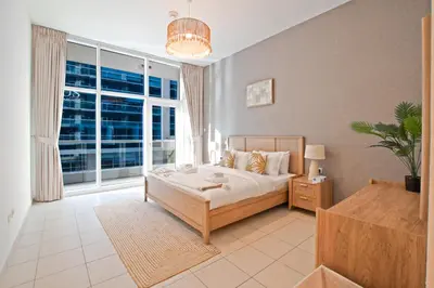a bedroom with a bed and a large window at Nivis find- Bay square -1 BHK in Dubai