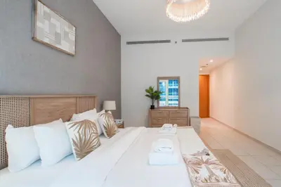 a bedroom with a large white bed with white pillows at Nivis find- Bay square -1 BHK in Dubai