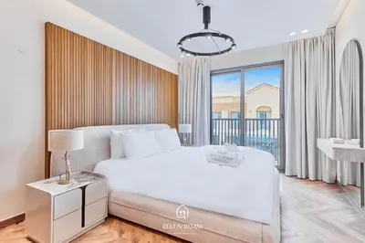 a bedroom with a white bed and a large window at Luxury Elie Saab 3BR Villa in Jasmine Lane in Dubai