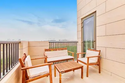 a balcony with two chairs and a table at Luxury Elie Saab 3BR Villa in Jasmine Lane in Dubai