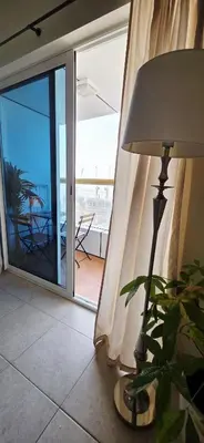 a lamp in a living room with a sliding glass door at Elite Residence, Marina in Dubai