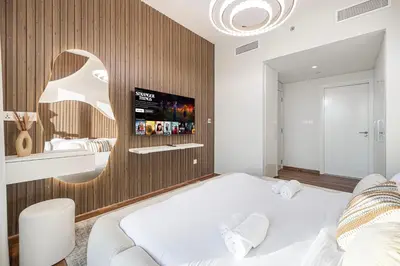 a bedroom with a bed and a tv on a wall at Modern Downtown Apartment plus Pool plus Khalifa View in Dubai