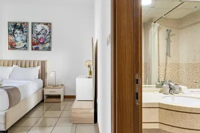 a bedroom with a bed and a bathroom with a tub at Modern 1BR in Dubai Marina with Balcony Gym & Pool in Dubai