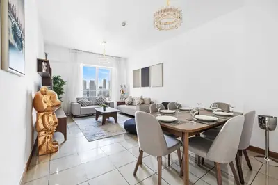 a dining room and living room with a table and chairs at Modern 1BR in Dubai Marina with Balcony Gym & Pool in Dubai