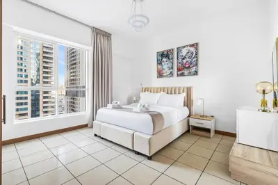 a bedroom with a bed and a large window at Modern 1BR in Dubai Marina with Balcony Gym & Pool in Dubai