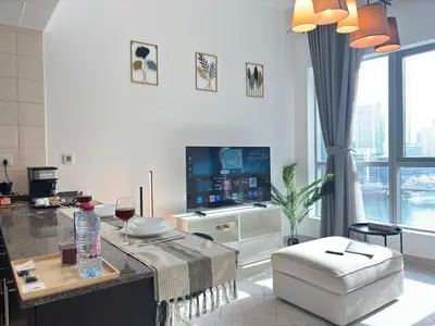 a living room with a table and a tv at 810 Elegant Marina View Apartment Near Tram, Dining & Nightlife, Bay Cental in Dubai
