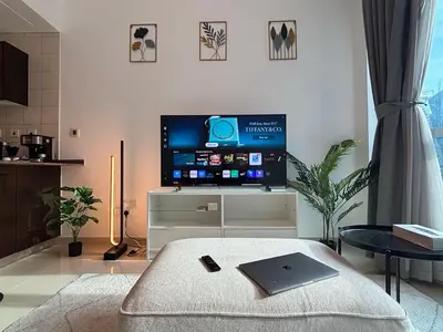 a living room with a tv and a laptop on a table at 810 Elegant Marina View Apartment Near Tram, Dining & Nightlife, Bay Cental in Dubai