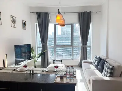 a living room with a couch and a table with wine glasses at 810 Elegant Marina View Apartment Near Tram, Dining & Nightlife, Bay Cental in Dubai