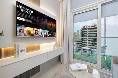 a living room with a large window and a tv at Stunning Canal View 1BR Apartment Burj Khalifa And Dubai Mall 10 Min Walk Ideal for Up to 4 Guests in Dubai