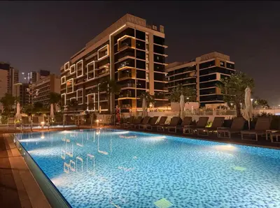 a swimming pool with swans in the water at night at Nature luxe estudio Dubai in Dubai