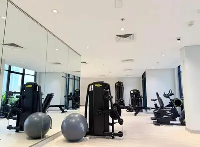 a gym with a lot of exercise equipment and mirrors at Nature luxe estudio Dubai in Dubai