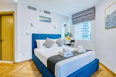 a bedroom with a large bed with a blue headboard at PVH - Dubai Gate 1 - Cozy Central Studio in JLT in Dubai
