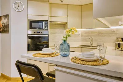 a kitchen with a table with plates and a vase of flowers at PVH - Dubai Gate 1 - Cozy Central Studio in JLT in Dubai