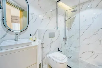 a bathroom with a toilet and a glass shower at PVH - Dubai Gate 1 - Cozy Central Studio in JLT in Dubai