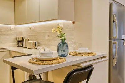 a kitchen with a table with a vase of flowers on it at PVH - Dubai Gate 1 - Cozy Central Studio in JLT in Dubai