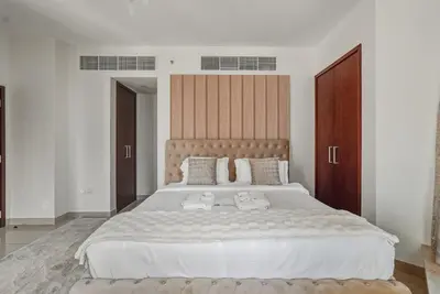a bedroom with a large white bed with white sheets at Downtown 1BR Full Burj Khalifa & Fountain Views in Dubai