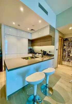 a kitchen with two bar stools and a kitchen counter at Luxury Apartment Marina in Dubai