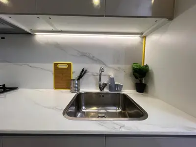 a kitchen sink in a white counter top at Urban SkyView Apartment Near Downtown Dubai in Dubai