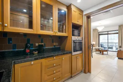 a kitchen with wooden cabinets and black counter tops at 5 Minutes Dubai Mall - Burj Khalifa - View pools in Dubai