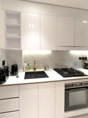 a white kitchen with a sink and a stove at 15 min from Dubai Marina & JBR beach Studio apartment AZURE BINGHATTI JVC in Dubai