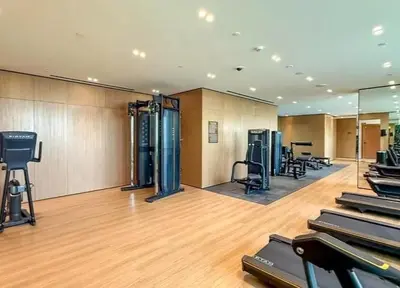 a gym with treadmills and machines in a room at 15 min from Dubai Marina & JBR beach Studio apartment AZURE BINGHATTI JVC in Dubai