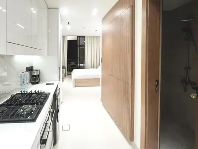 a kitchen with a stove and a kitchen with a bed at 15 min from Dubai Marina & JBR beach Studio apartment AZURE BINGHATTI JVC in Dubai