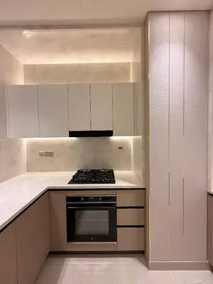 a kitchen with white cabinets and a stove top oven at The Royale Mocha Jacuzzi Suite 34-10 I JVC I Dar Oasis in Dubai