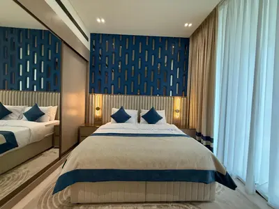 a bedroom with two beds and a blue wall at The Royale Mocha Jacuzzi Suite 34-10 I JVC I Dar Oasis in Dubai