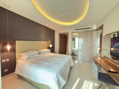 a bedroom with a large bed and a flat screen tv at AMAKIN Damac Paramount in Dubai