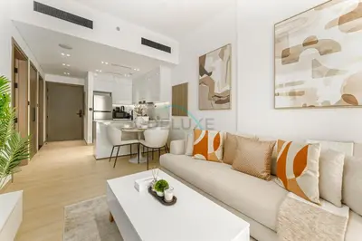 a living room with a couch and a table at Located Near Community Parks, Convenient Stores, an RTA Bus Stop, And Just Minutes From The Mall - Binghatti Emerald, JVC by Deluxe Holiday Homes in Dubai