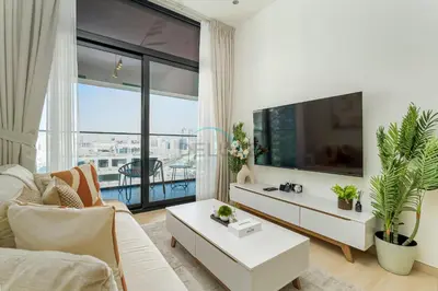 a living room with a couch and a tv at Located Near Community Parks, Convenient Stores, an RTA Bus Stop, And Just Minutes From The Mall - Binghatti Emerald, JVC by Deluxe Holiday Homes in Dubai