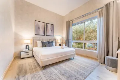 a bedroom with a large bed and a large window at 4BR plus Maids Room Villa Near Nad Al Sheba Mall, With Easy Access to Major Dubai Attractions - Nad Al Shiba Third, Nad Al Sheba by Deluxe Holiday Homes in Dubai