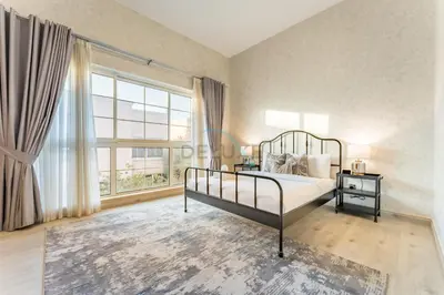 a bedroom with a bed and a large window at 4BR plus Maids Room Villa Near Nad Al Sheba Mall, With Easy Access to Major Dubai Attractions - Nad Al Shiba Third, Nad Al Sheba by Deluxe Holiday Homes in Dubai