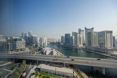 a city with a bridge and a river and buildings at Dubai Water Canal View, Minutes away from Burj Khalifa and Dubai Mall, Near Metro Bus Station - Prive by Damac B, Business Bay by Deluxe Holiday Homes in Dubai