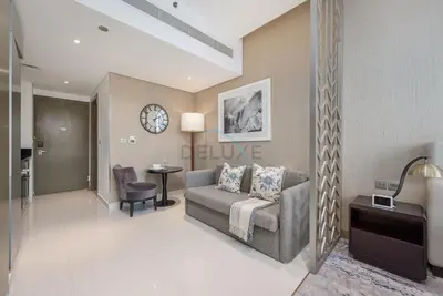 a living room with a couch and a clock on the wall at Dubai Water Canal View, Minutes away from Burj Khalifa and Dubai Mall, Near Metro Bus Station - Prive by Damac B, Business Bay by Deluxe Holiday Homes in Dubai