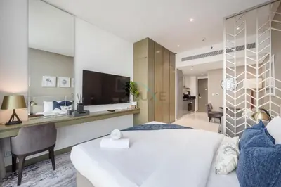 a bedroom with a bed and a desk with a television at Dubai Water Canal View, Minutes away from Burj Khalifa and Dubai Mall, Near Metro Bus Station - Prive by Damac B, Business Bay by Deluxe Holiday Homes in Dubai