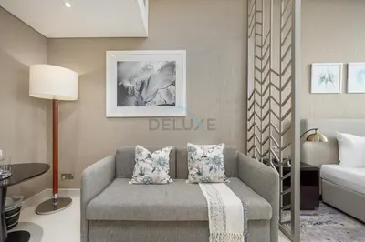a living room with a couch and a bed at Dubai Water Canal View, Minutes away from Burj Khalifa and Dubai Mall, Near Metro Bus Station - Prive by Damac B, Business Bay by Deluxe Holiday Homes in Dubai